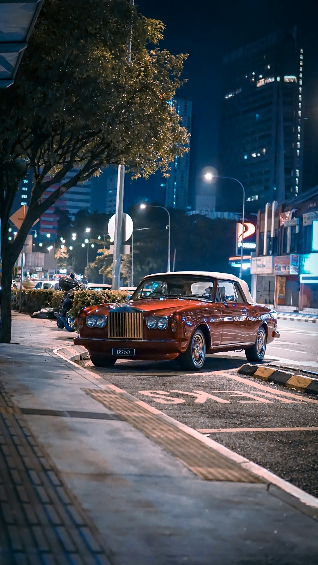 Vintage Italian sports car parked in front of a historic Montevideo building