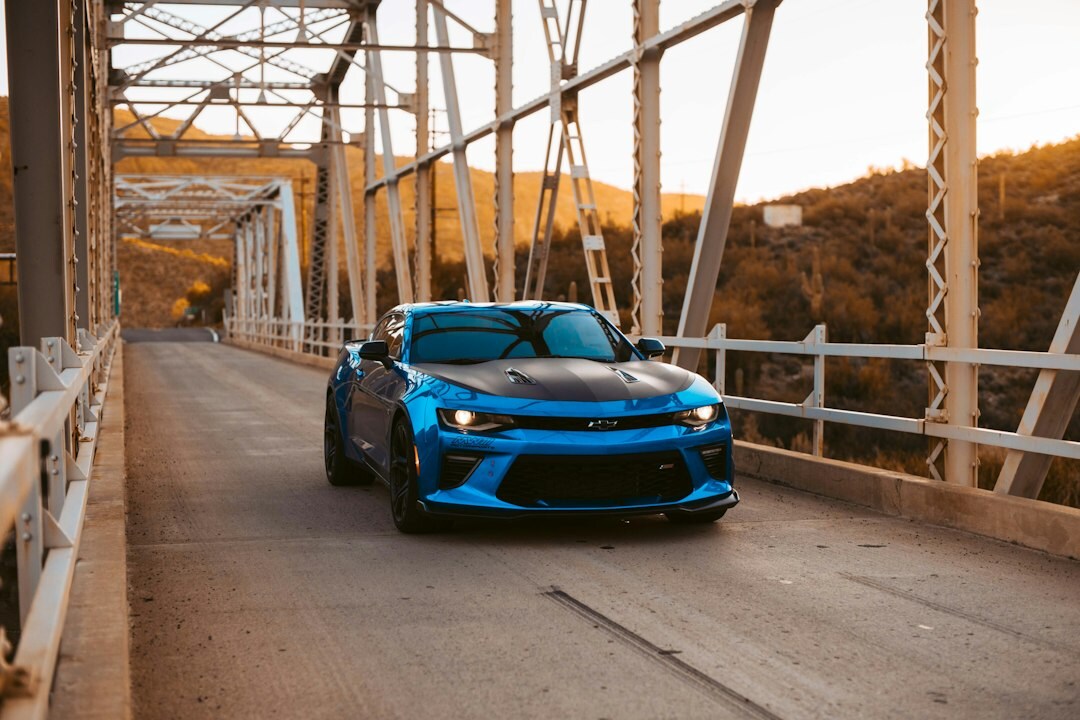 Vintage sports car crossing a bridge on the coast of Punta del Este at sunset